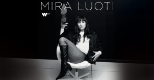 Mustavalkoinen kuva, jossa Mira Luoti istuu tuolilla