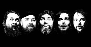 Mustavalkoinen kuva, jossa yhtyeen jäsenten kasvot vaalealla