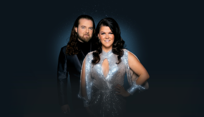 Tumma tausta, jossa seisovat Teemu Roivainen ja Saara Aalto