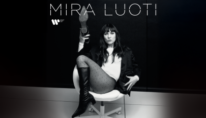 Mustavalkoinen kuva, jossa Mira Luoti istuu tuolilla