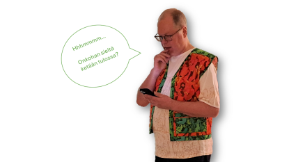 Kuvataiteilija Petri Kaverma pukeutuneena maastokuvioiseen liiviin ja puhelin kädessä. 