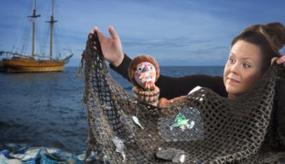 Yksi henkilö ja nukke pitelemässä kalaverkkoa.