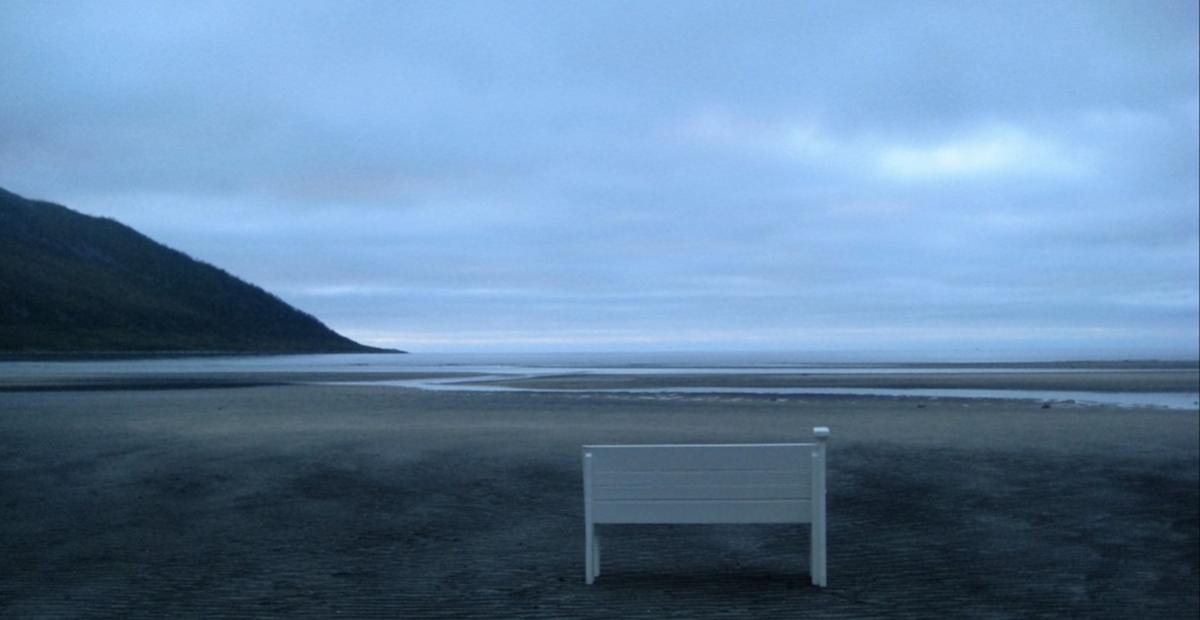 Kuvassa on penkki rannalla.